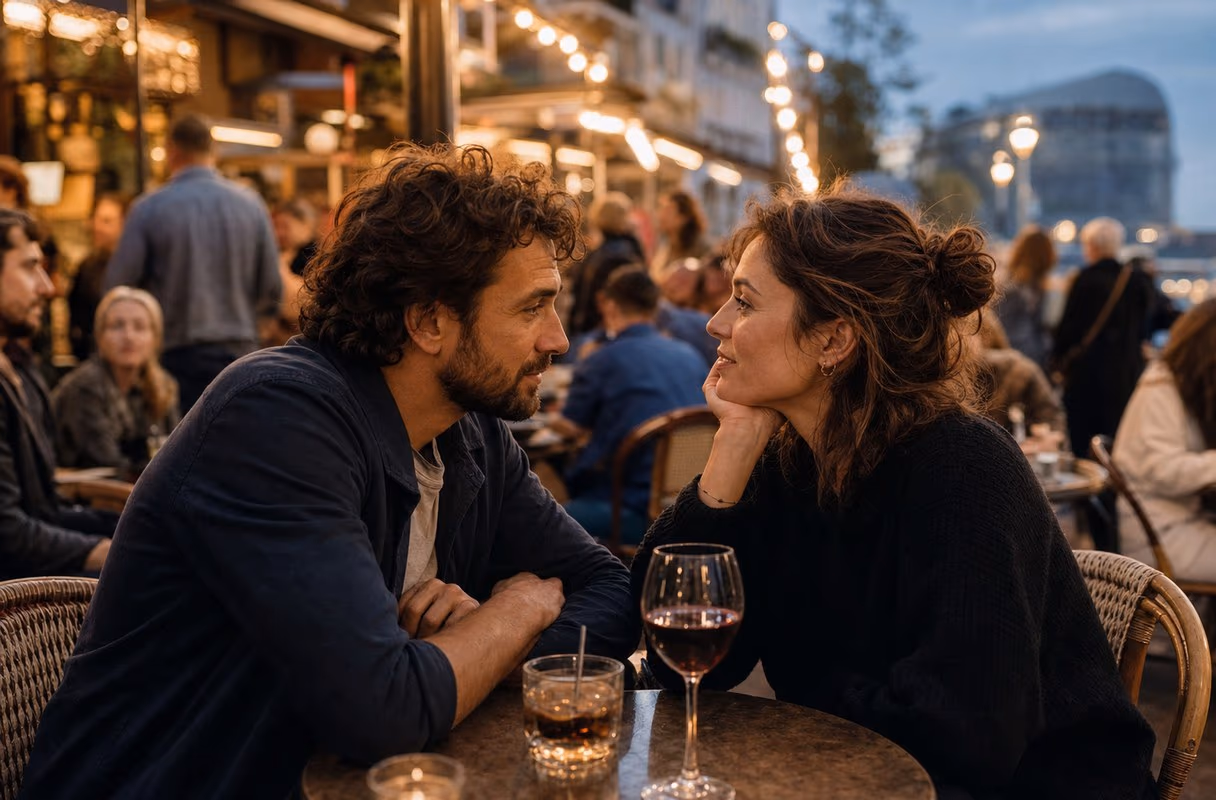 A couple talking closely at a café table in the Pâquis quarter in the evening