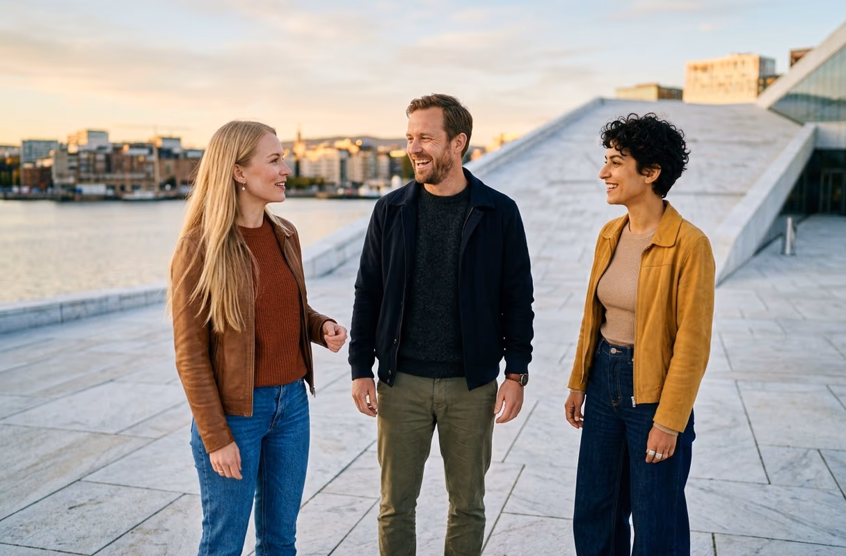 Three people talking on the sloping white roof of the Oslo Opera House by the fjord